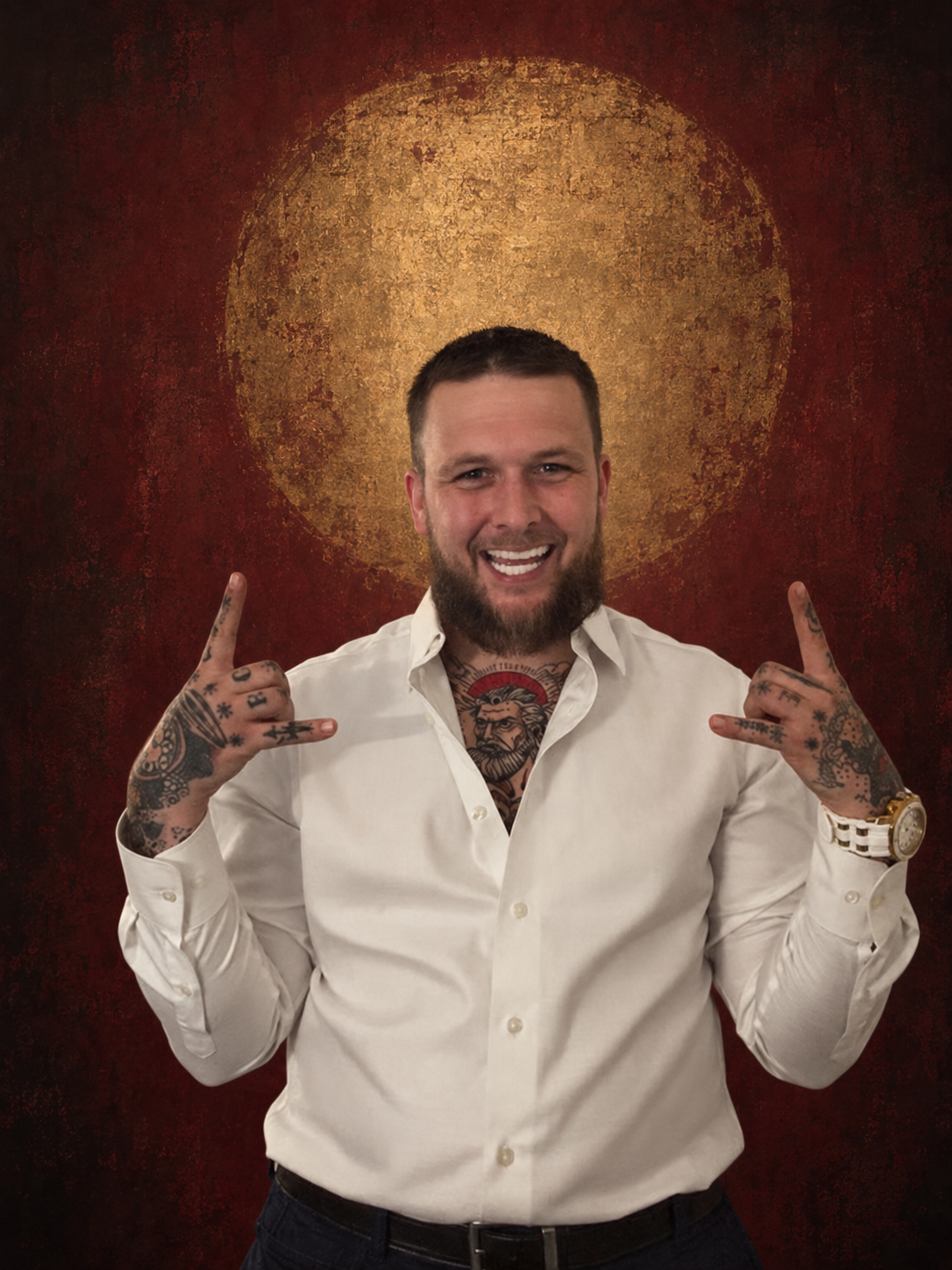 The founder of Thread and Flash smiling, with his hand and chest tattoos visible, against an edited oxblood studio backdrop